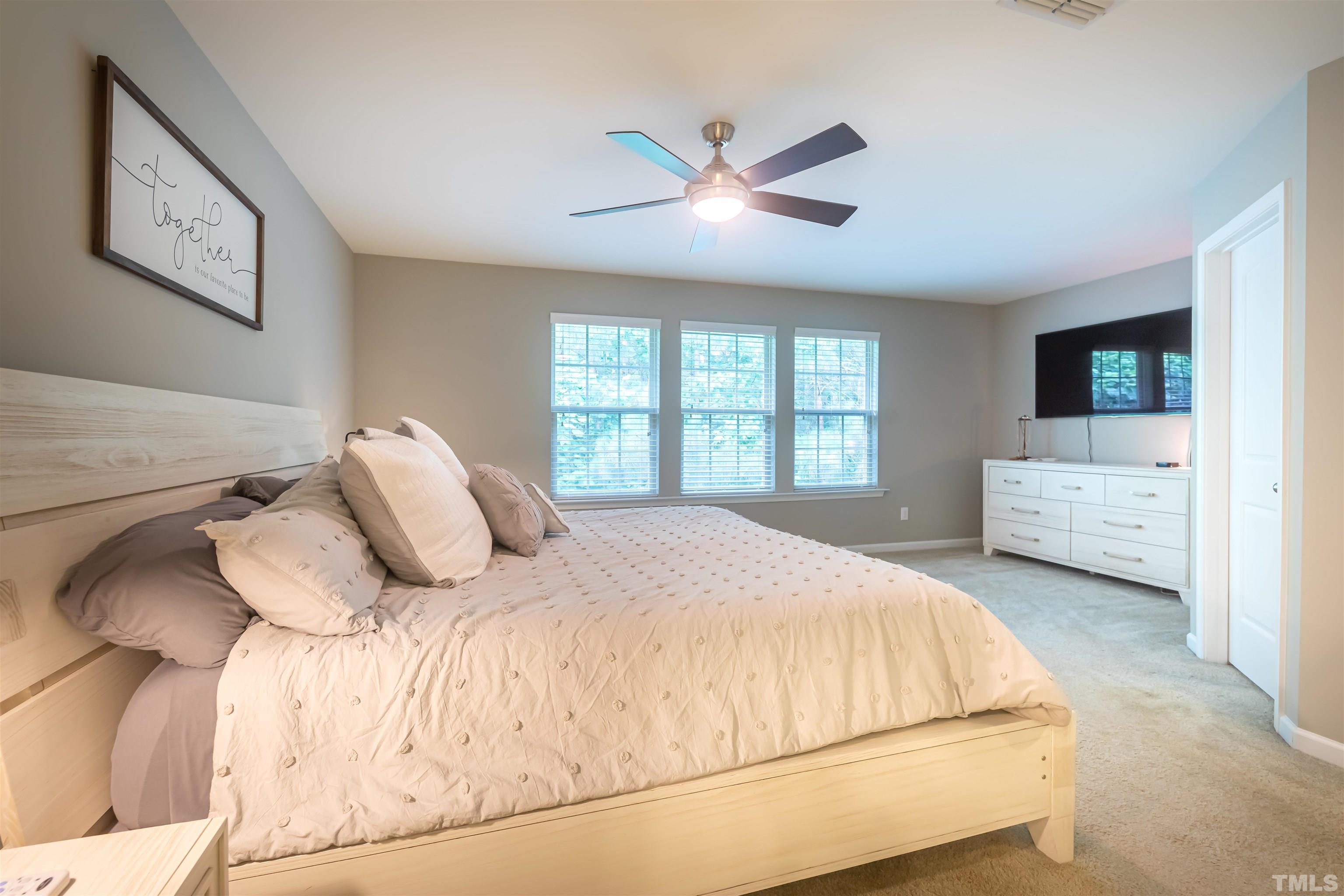 1427 Chatuga Way Wake Forest, NC 27587 - Photo 17 of 36 a bedroom with a large bed and a tv