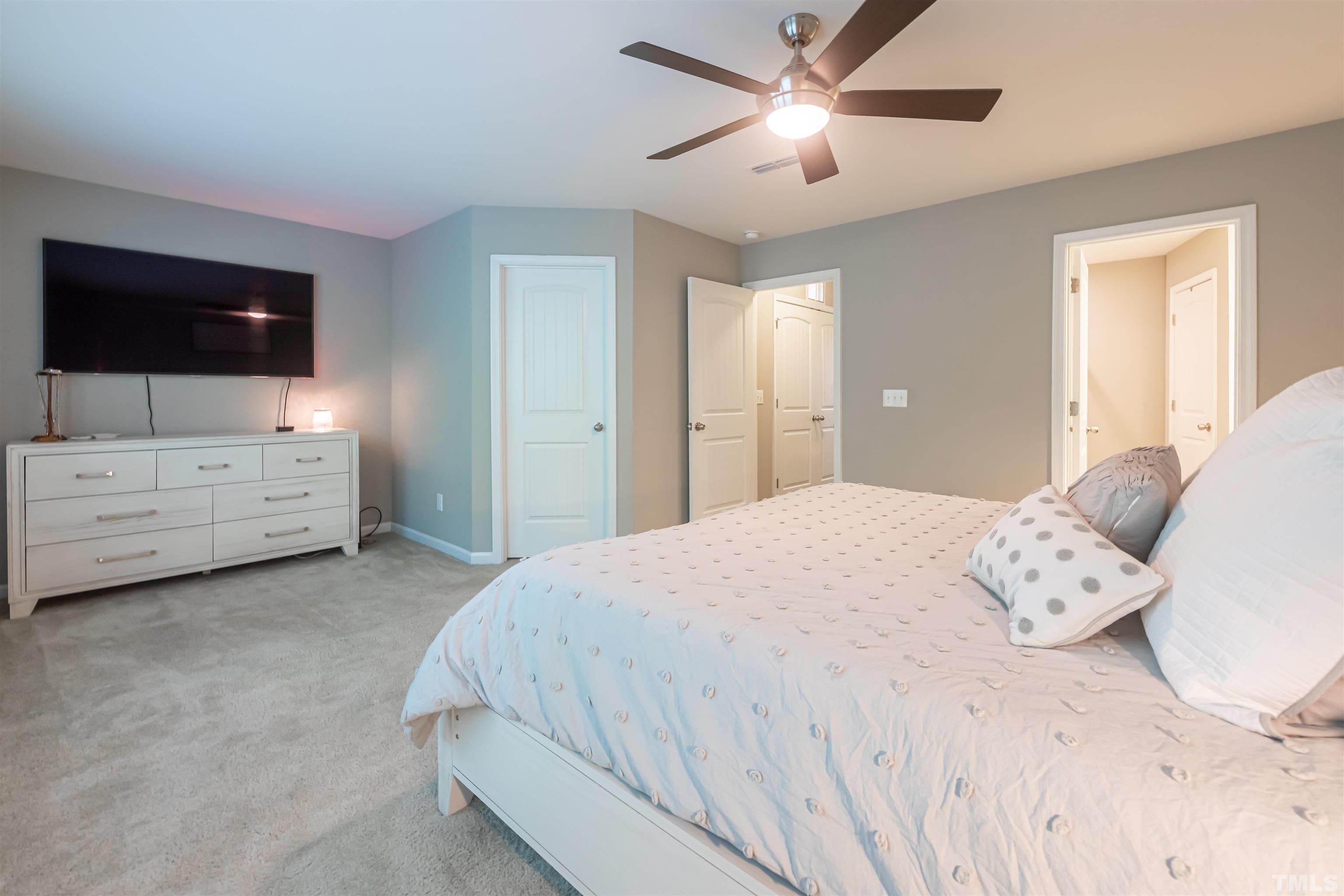 1427 Chatuga Way Wake Forest, NC 27587 - Photo 21 of 36 a bedroom with a bed and a flat screen tv
