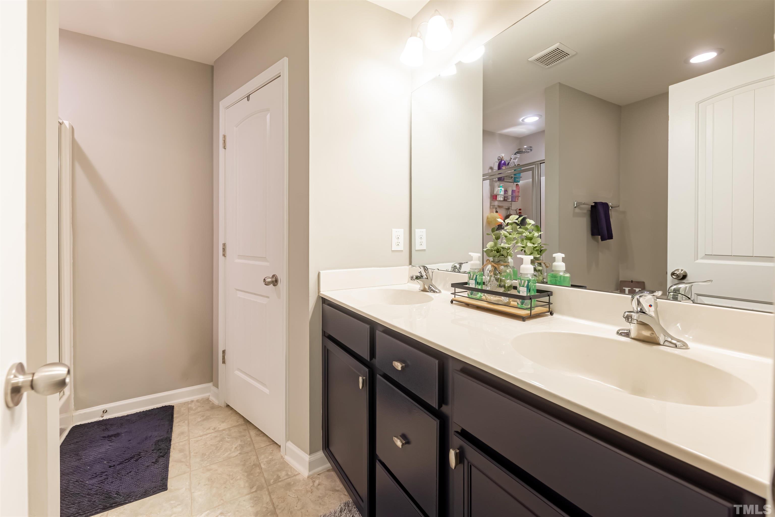 1427 Chatuga Way Wake Forest, NC 27587 - Photo 22 of 36 a bathroom with a double vanity sink a mirror and a