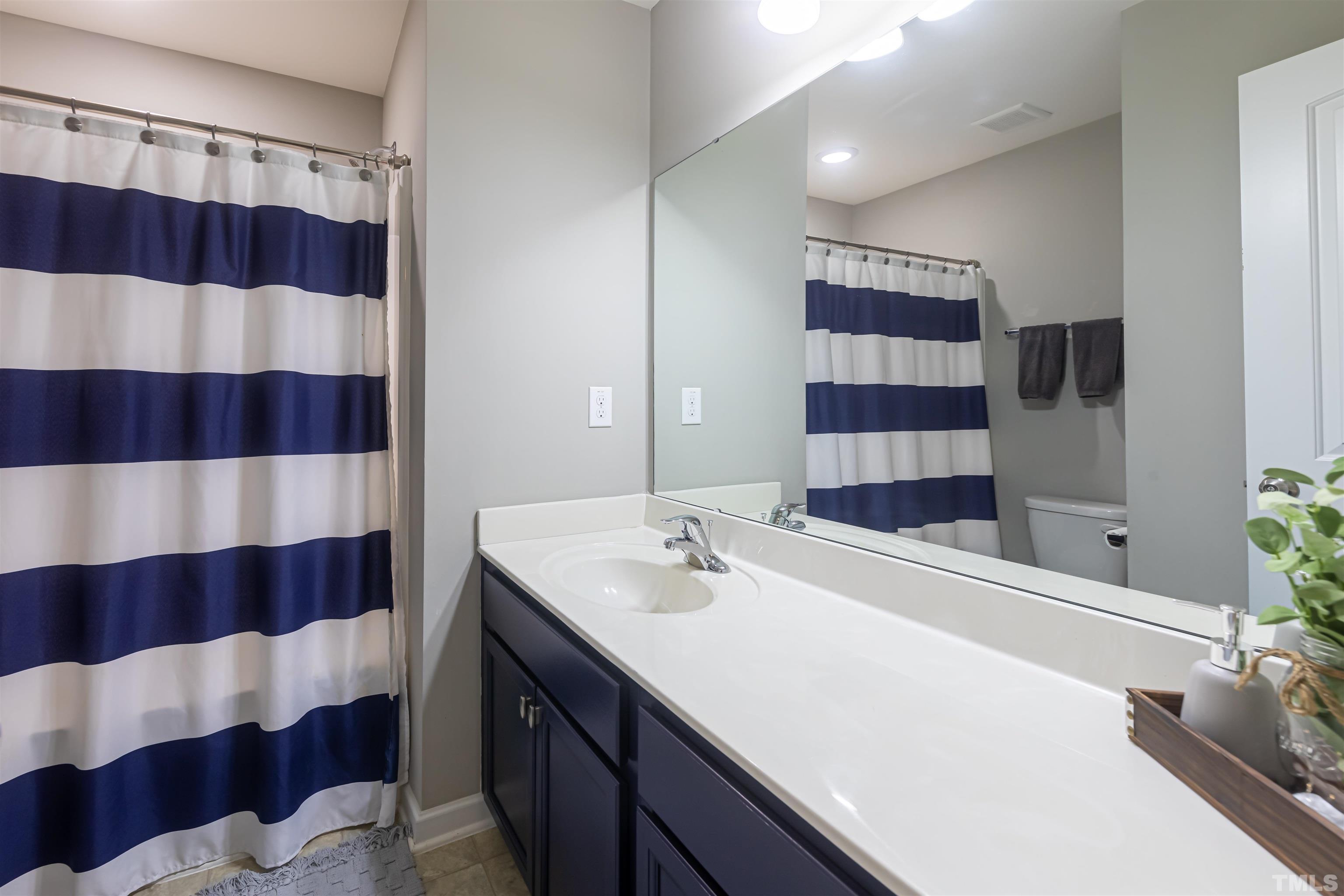 1427 Chatuga Way Wake Forest, NC 27587 - Photo 28 of 36 a bathroom with a sink and a mirror