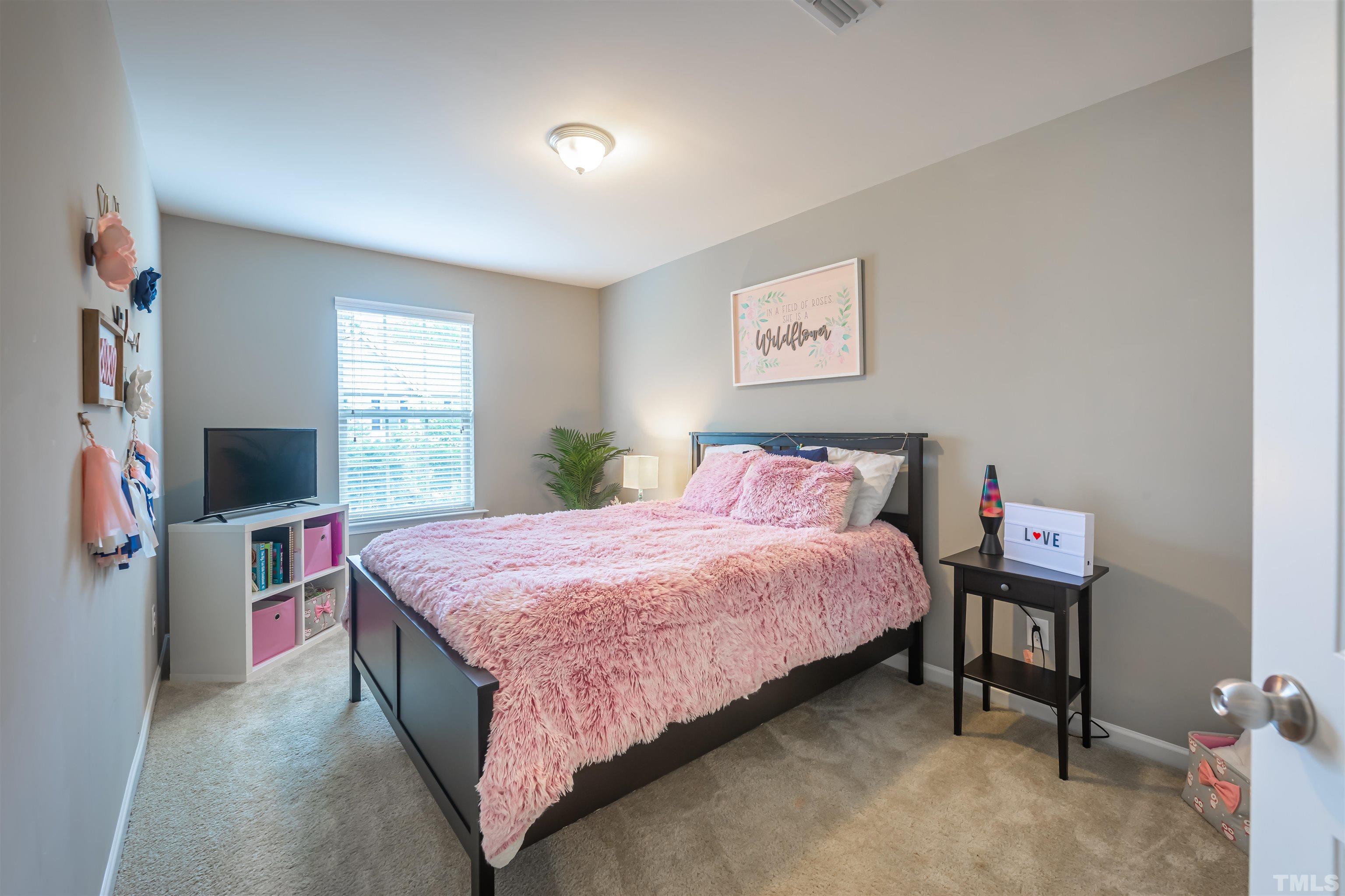 1427 Chatuga Way Wake Forest, NC 27587 - Photo 29 of 36 a bedroom with a bed and a flat screen tv