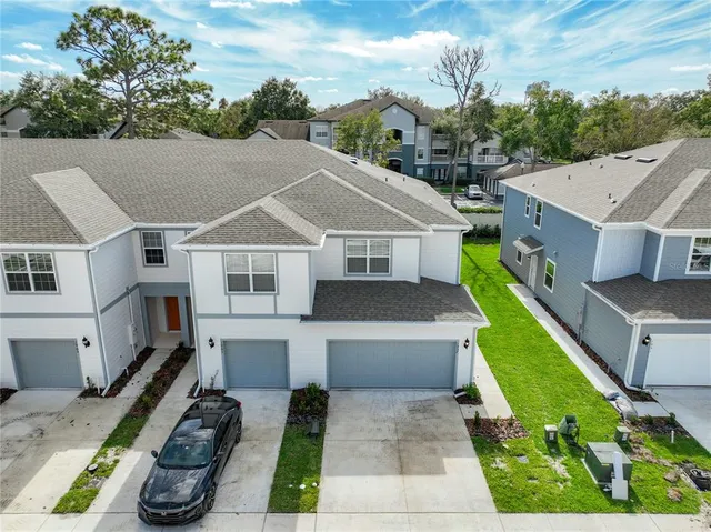 a aerial view of a house with a yard table and chairs