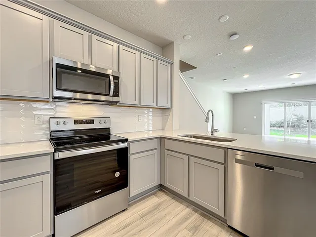 a large kitchen with cabinets and stainless steel appliances