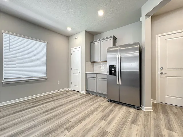 a kitchen with stainless steel appliances granite countertop a refrigerator a stove and a sink