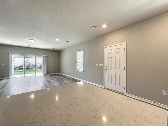 a kitchen with granite countertop a refrigerator a sink a stove a microwave and island