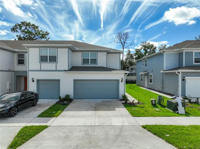 a front view of a house with a yard and a garage
