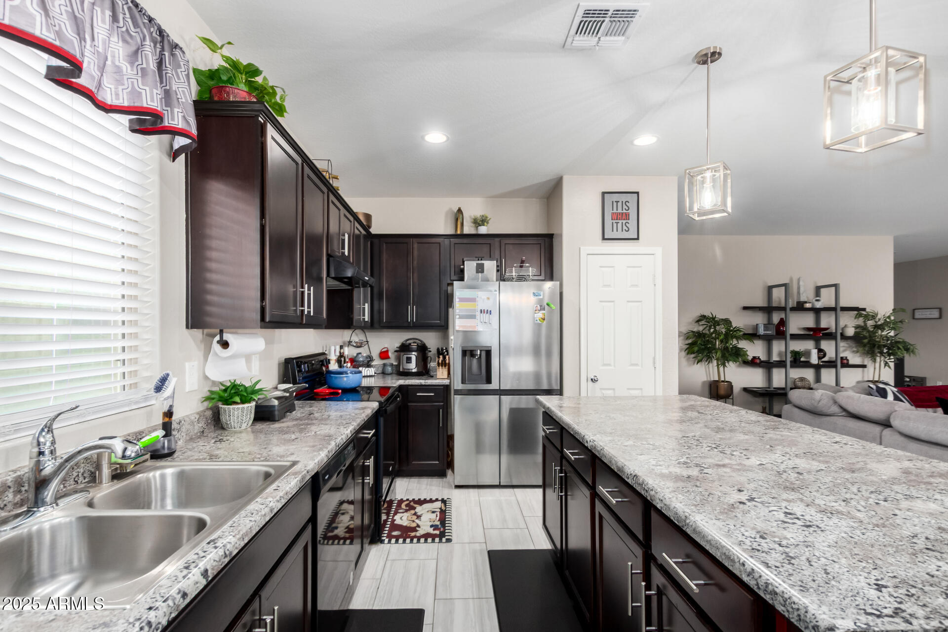 10637 West Crown King Road Tolleson, AZ 85353 - Photo 4 of 19 a kitchen with granite countertop a sink a counter space appliances and cabinets