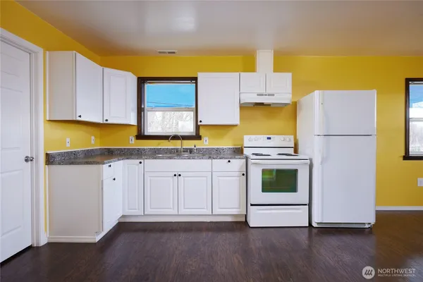 a kitchen with a sink a stove and cabinets