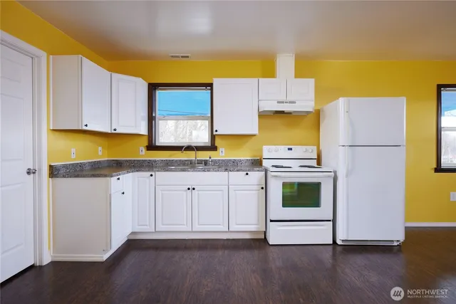 a kitchen with a sink a stove and cabinets
