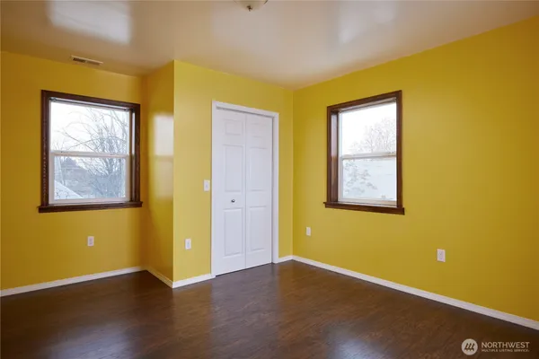 a view of a room with wooden floor and windows