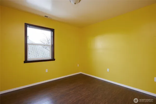 a view of a small space with wooden floor and a window