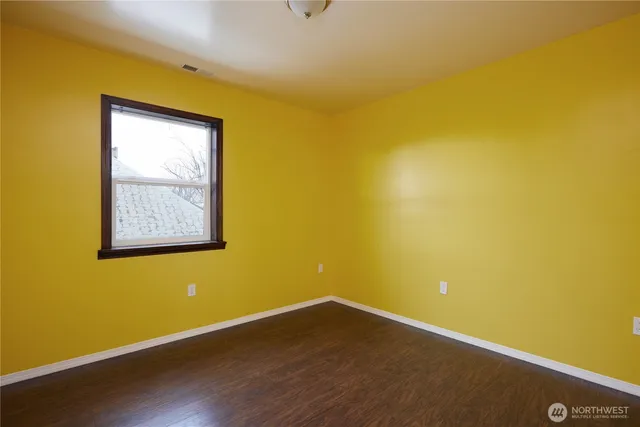 a view of a small space with wooden floor and a window