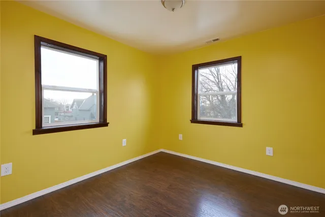 a view of a blue wall with wooden floor and a window