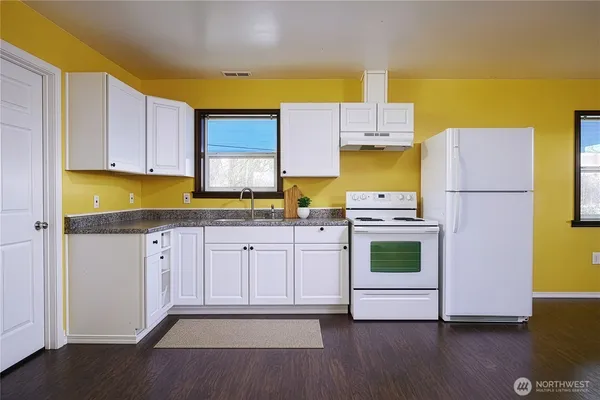 a kitchen with a white stove top oven and white cabinets