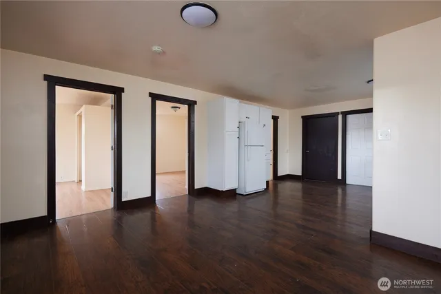 a view of an empty room with wooden floor and closet