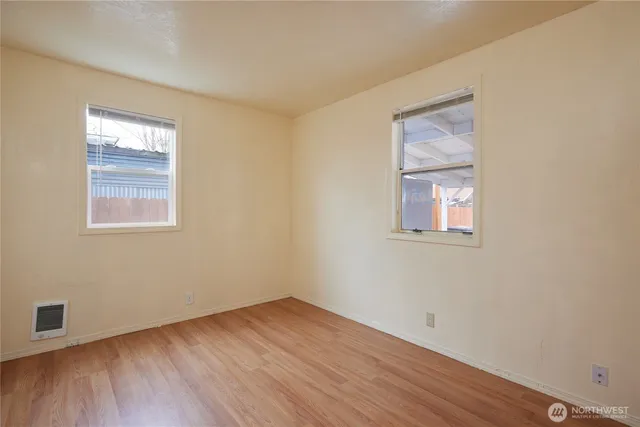 a view of a room that has wooden floor and window