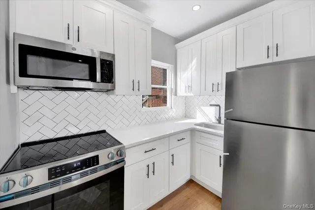 a kitchen with white cabinets and stainless steel appliances