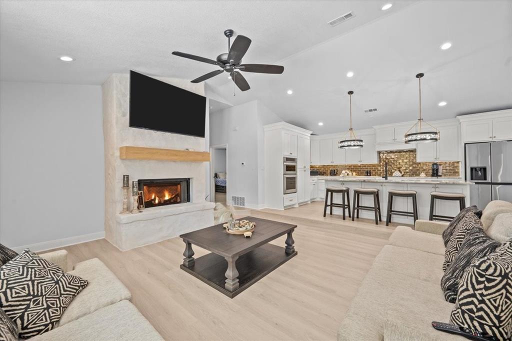 1107 Bays Road Axtell, TX 76624 - Photo 1 of 1 Living area with lofted ceiling, light wood-style flooring, a fireplace, ceiling fan, and recessed lighting