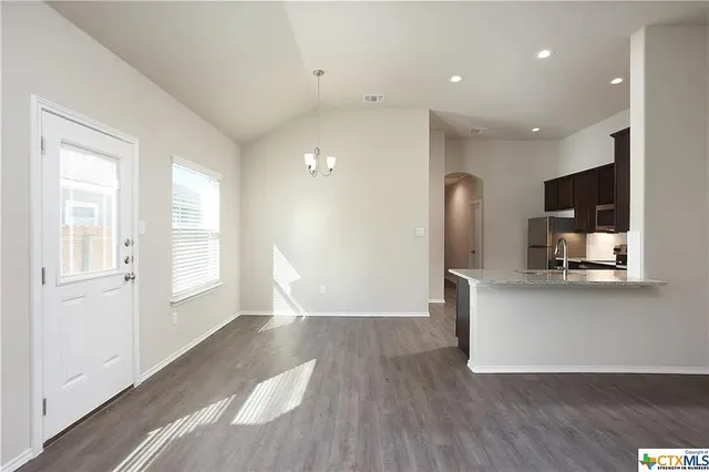a view of a kitchen with furniture and wooden floor