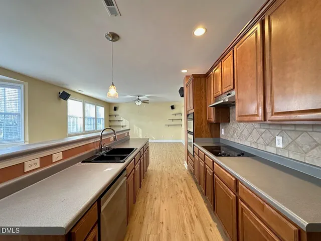 a kitchen with a sink a counter top space stainless steel appliances and a window