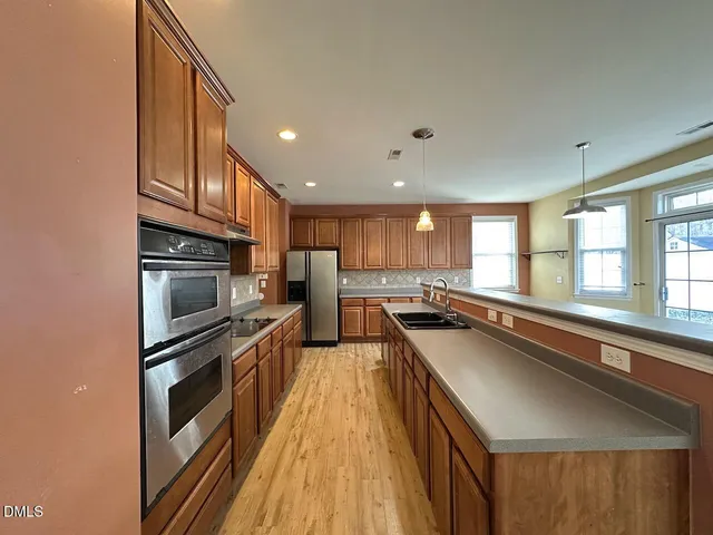 a kitchen with stainless steel appliances a sink stove and cabinets