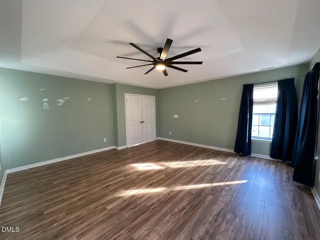 a view of a livingroom with a hardwood floor and a ceiling fan
