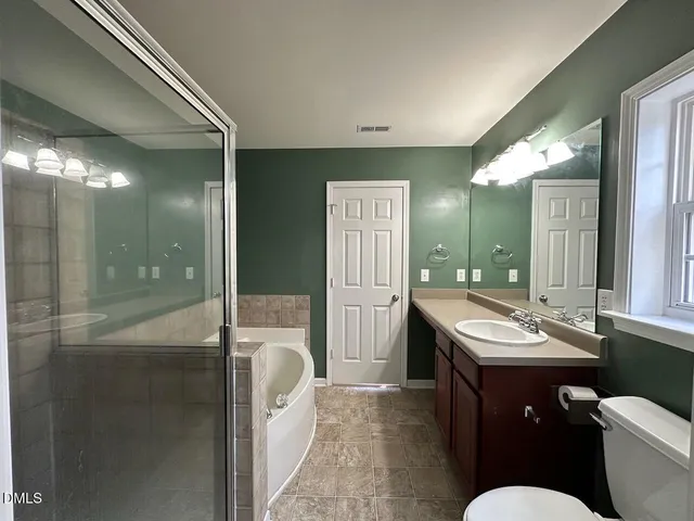 a bathroom with a sink a toilet a mirror and shower