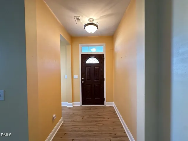 a view of an entryway door with a hallway