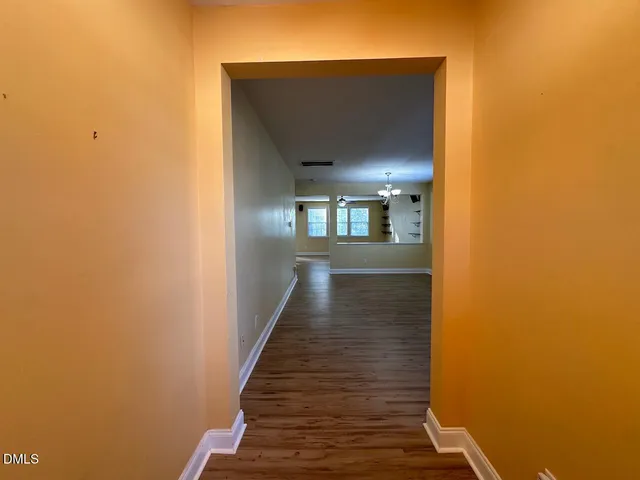 a view of a hallway with wooden floor and staircase