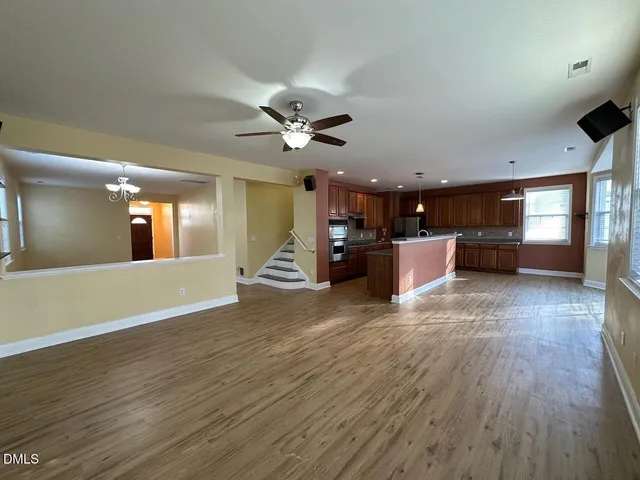 a view of a living room a kitchen and a wooden floor