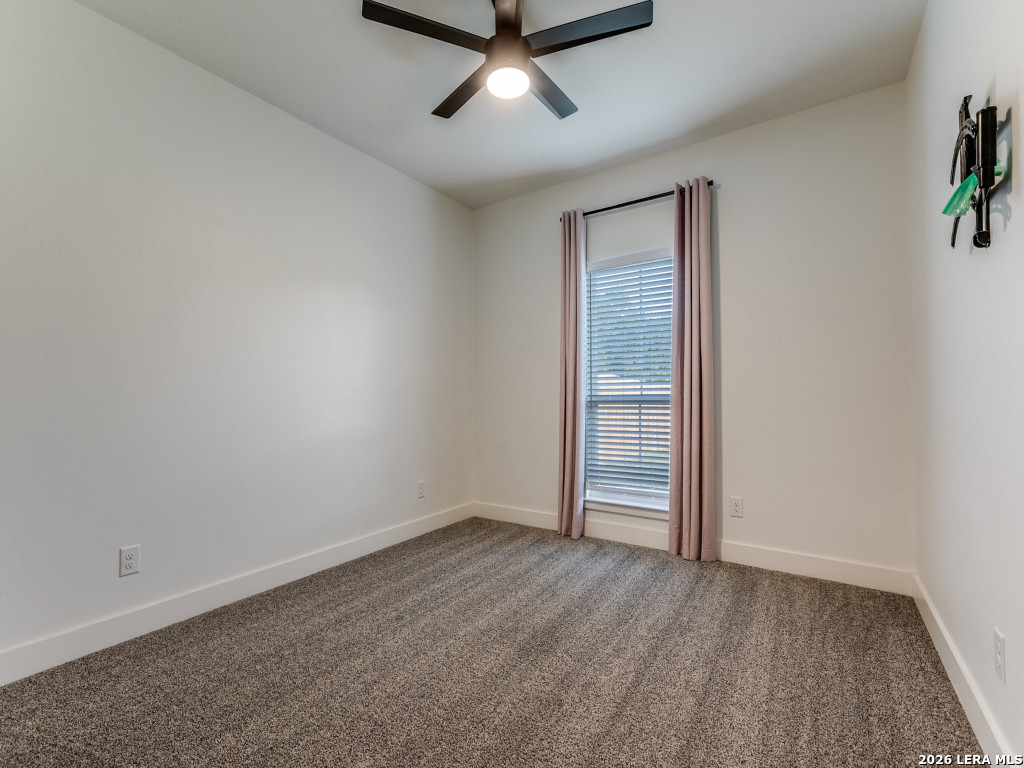 1015 Timbercrest Pleasanton, TX 78064 - Photo 20 of 26 an empty room with a ceiling fan and windows