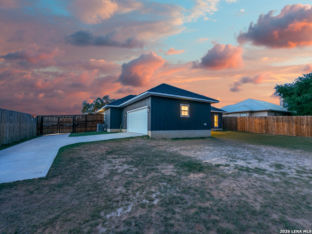 1015 Timbercrest Pleasanton, TX 78064 - Photo 24 of 26 a view of a grey house with a yard