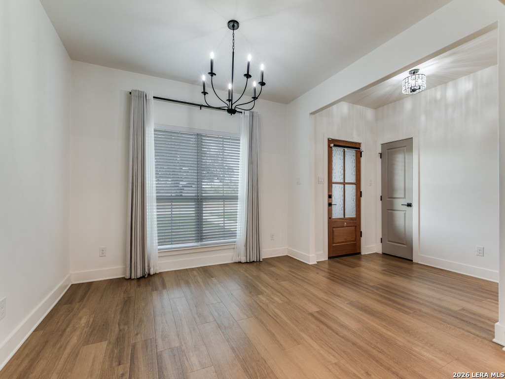 1015 Timbercrest Pleasanton, TX 78064 - Photo 5 of 26 a view of an empty room with wooden floor and a window