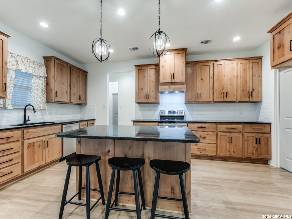 1015 Timbercrest Pleasanton, TX 78064 - Photo 9 of 26 a large kitchen with cabinets wooden floor and stainless steel appliances