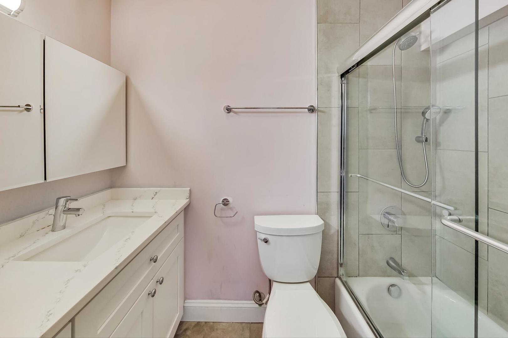 5445 North Sheridan Road, Unit 1706 Chicago, IL 60640 - Photo 14 of 26 a bathroom with a sink toilet and shower