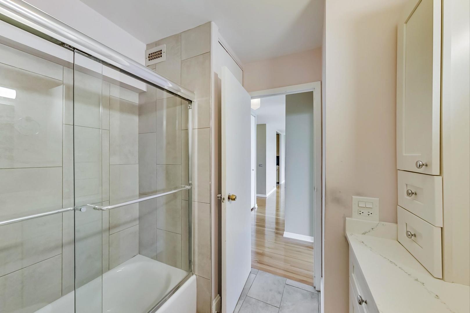 5445 North Sheridan Road, Unit 1706 Chicago, IL 60640 - Photo 15 of 26 a bathroom with a shower and a tub