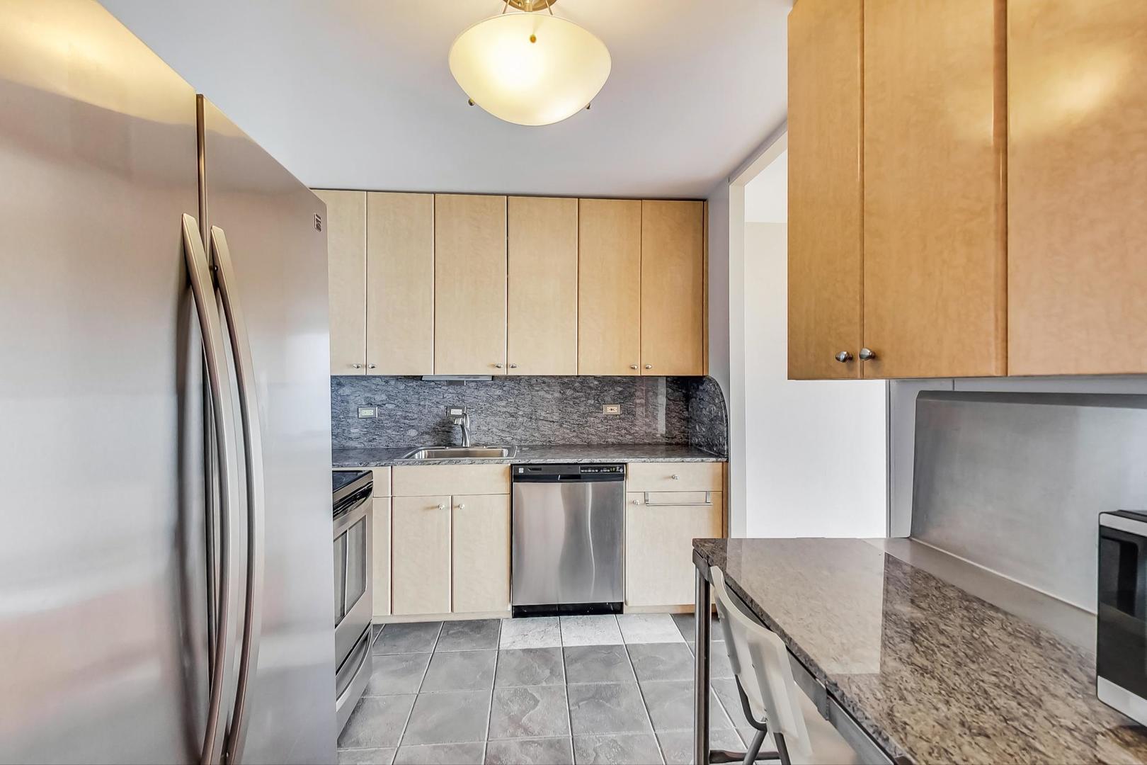 5445 North Sheridan Road, Unit 1706 Chicago, IL 60640 - Photo 7 of 26 a kitchen with stainless steel appliances granite countertop a refrigerator and a stove