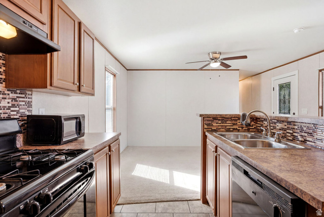 2875 North Hill Field Road, Unit 62 Layton, UT 84041 - Photo 13 of 34 Kitchen featuring wood-finish cabinetry, a mosaic tile backsplash, double basin sink, and a black built-in dishwasher