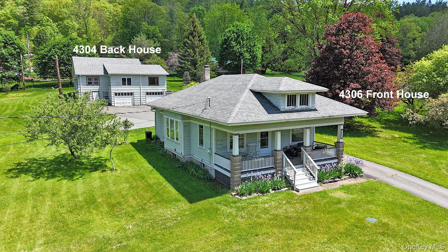 a view of a house with a big yard plants and large trees