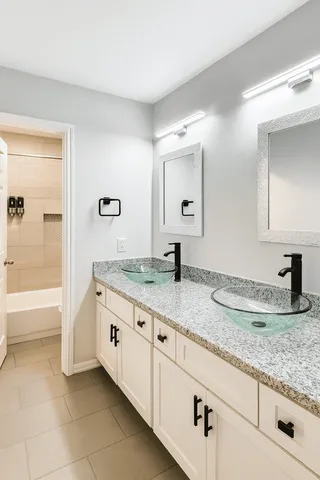 a bathroom with a granite countertop sink and a mirror