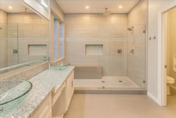 a bathroom with a granite countertop tub a sink and a large mirror