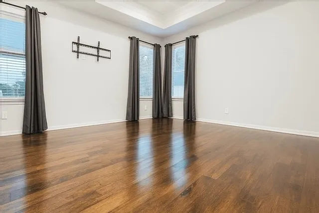a view of an empty room with wooden floor
