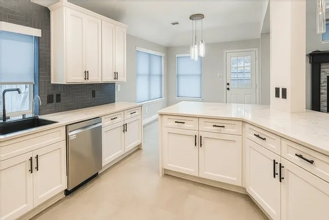 a kitchen with white cabinets and white appliances
