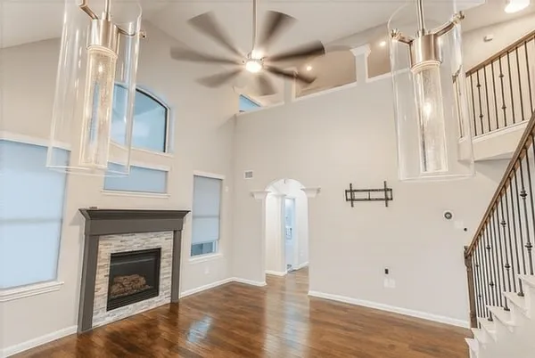 a view of an empty room with wooden floor and a fireplace