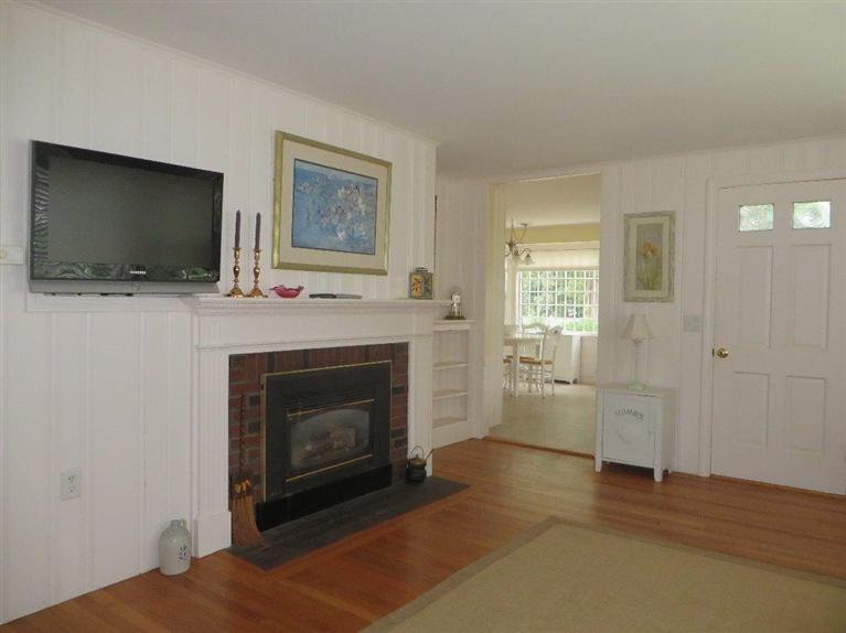 157 Lower County Road West Harwich, MA 02671 - Photo 3 of 14 a living room with furniture a flat screen tv and a fireplace