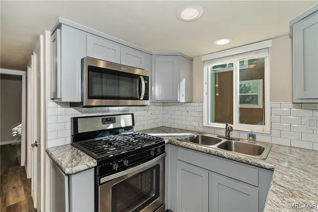 a kitchen with a sink stove and microwave