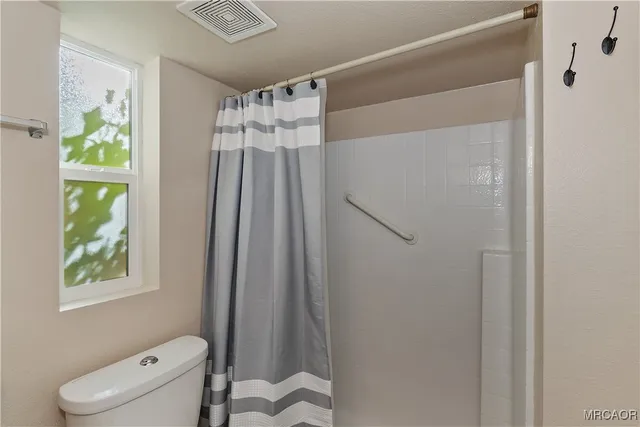 a bathroom with a shower a toilet and a sink