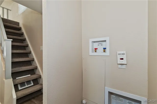 a view of hallway with stairs and wooden floor