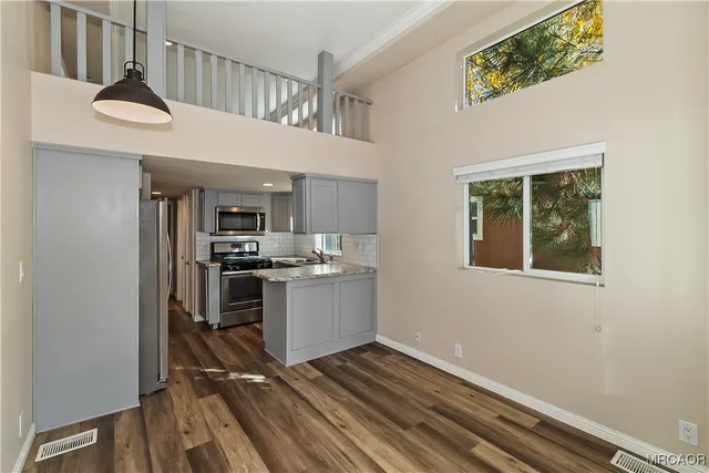 a kitchen with kitchen island a counter top space a sink stainless steel appliances and cabinets