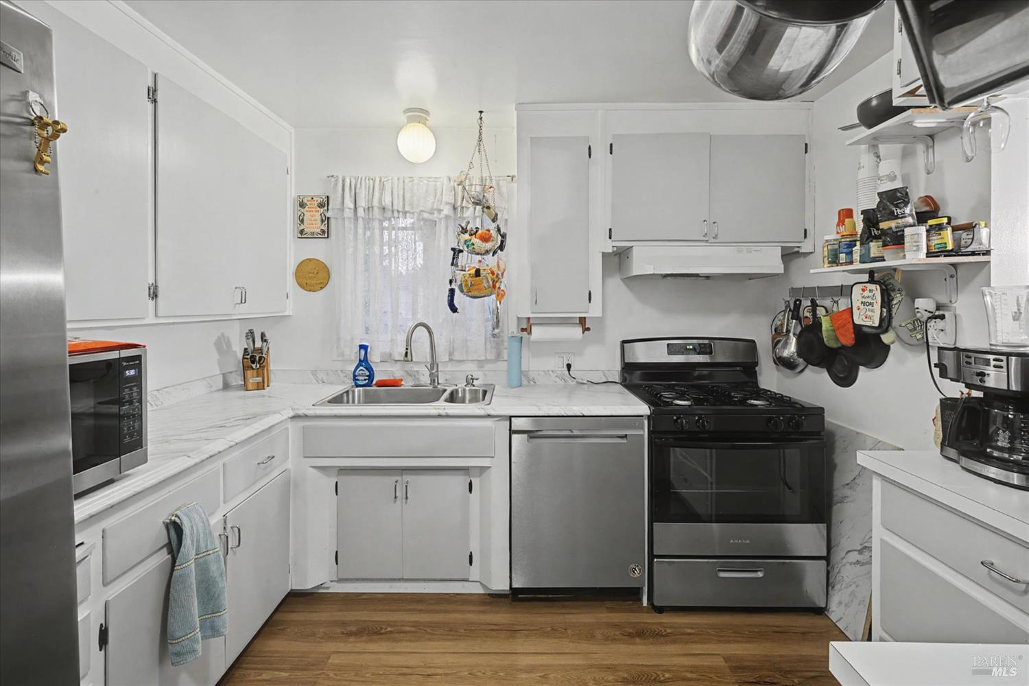 1763 E Street Napa, CA 94559 - Photo 7 of 31 a kitchen with a sink dishwasher and cabinets with wooden floor